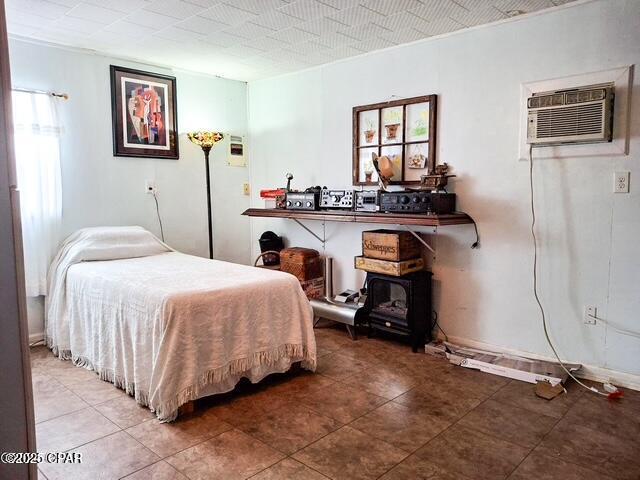 bedroom with a wall unit AC and baseboards