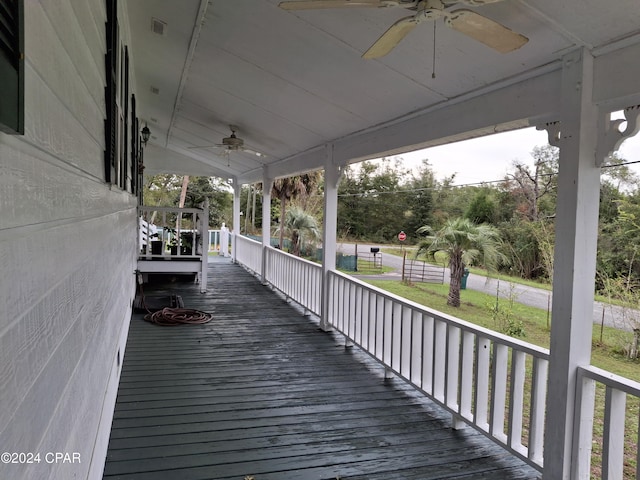 wooden terrace with ceiling fan and covered porch