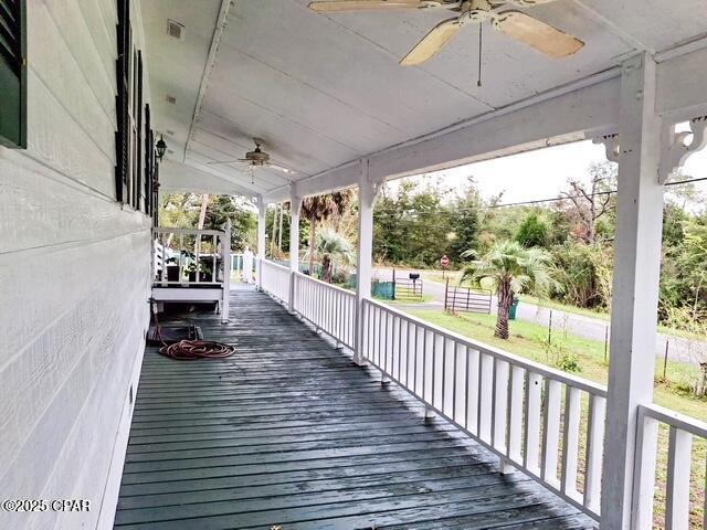 wooden terrace with covered porch and ceiling fan