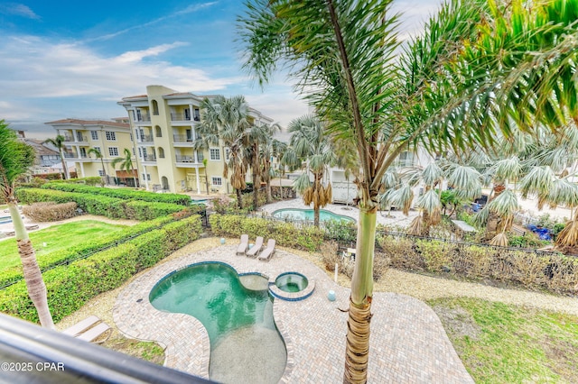 view of pool with a pool with connected hot tub, a fenced backyard, and a patio