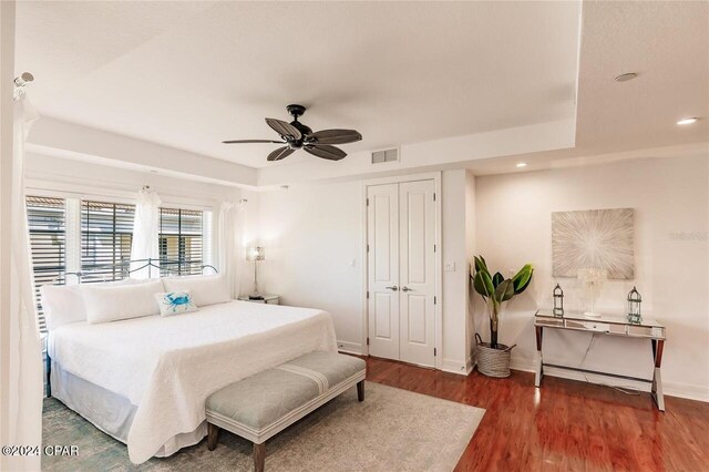 bedroom with a closet, ceiling fan, and dark wood-type flooring