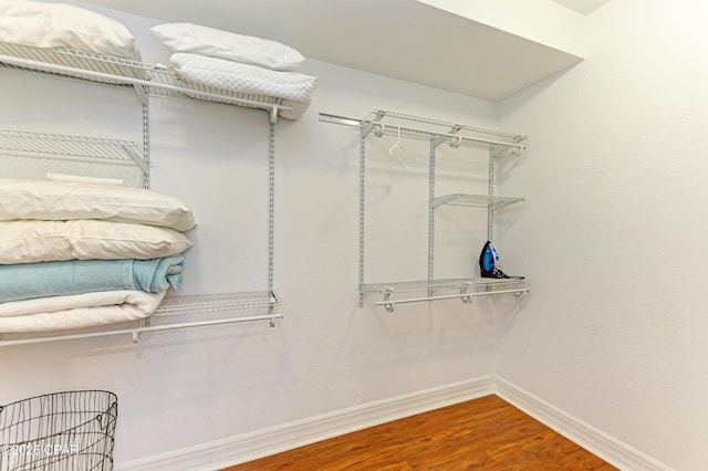 walk in closet with wood finished floors