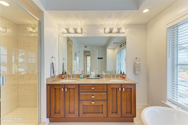 bathroom with a stall shower, a freestanding tub, a sink, and double vanity