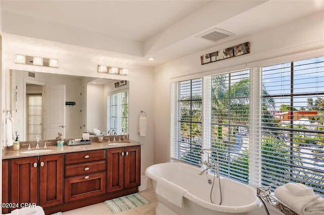 bathroom featuring a bathtub, vanity, and tile patterned flooring