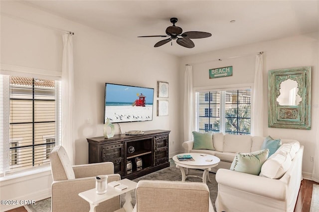 living room with baseboards and a ceiling fan