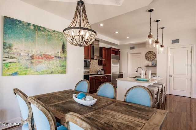 dining area with sink, a chandelier, and dark hardwood / wood-style floors