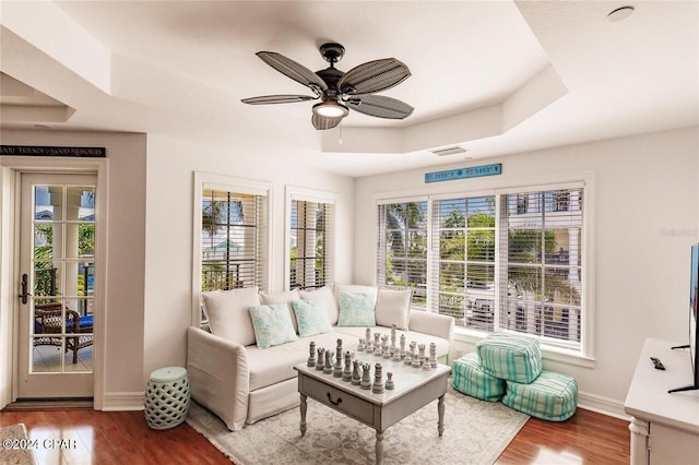 sunroom / solarium with a tray ceiling and ceiling fan