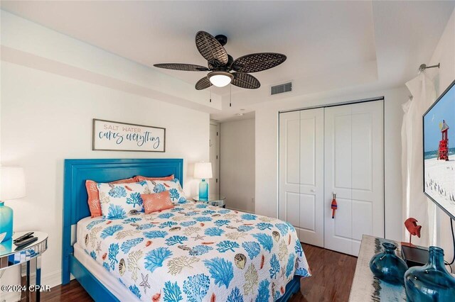 bedroom featuring ceiling fan, dark hardwood / wood-style floors, and a closet