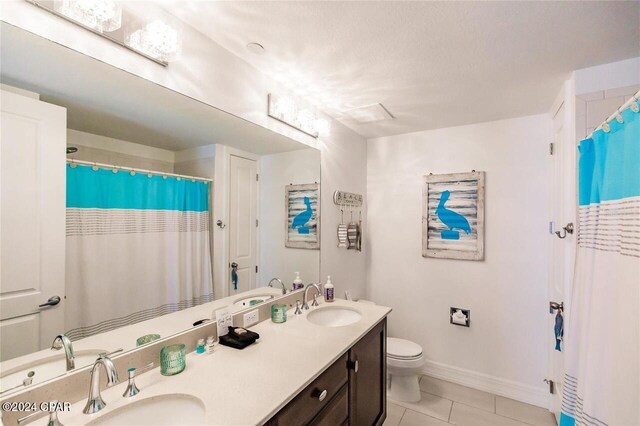 bathroom featuring tile patterned floors, vanity, and toilet