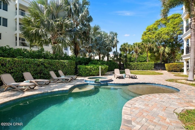 view of swimming pool featuring an in ground hot tub and a patio