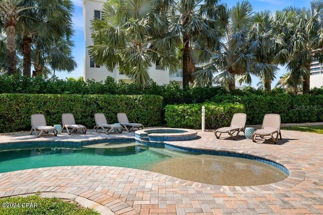 view of pool featuring an in ground hot tub and a patio area