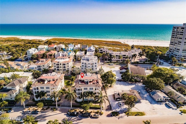 birds eye view of property featuring a water view and a beach view