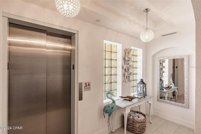 interior space featuring elevator and a chandelier