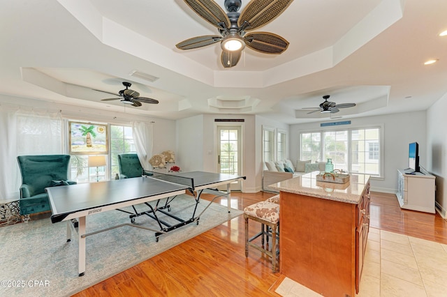 rec room with recessed lighting, visible vents, baseboards, light wood finished floors, and a raised ceiling