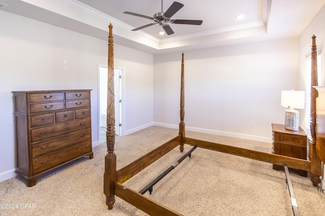 carpeted bedroom with a raised ceiling, ceiling fan, and ornamental molding