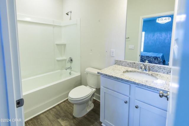 full bathroom featuring hardwood / wood-style floors, vanity, toilet, and shower / washtub combination