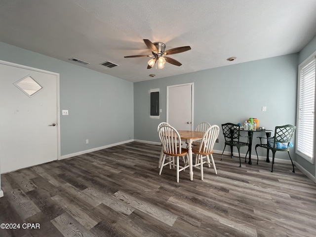 dining space featuring a textured ceiling, electric panel, ceiling fan, and dark wood-type flooring