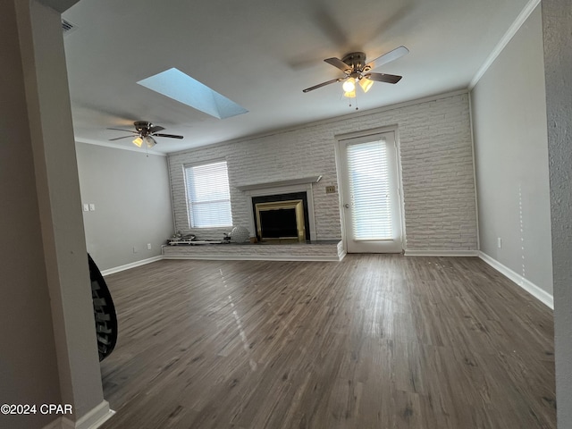 unfurnished living room featuring a skylight, a wealth of natural light, crown molding, and dark hardwood / wood-style floors