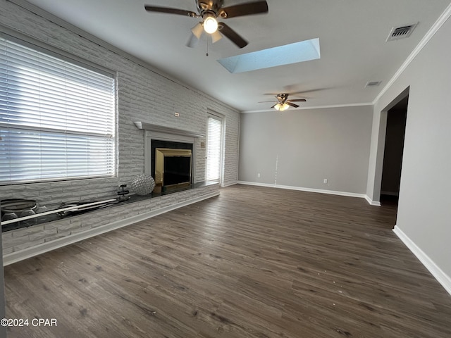 unfurnished living room featuring crown molding, dark wood-type flooring, and a skylight