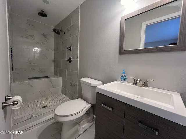 bathroom with a tile shower, vanity, and toilet