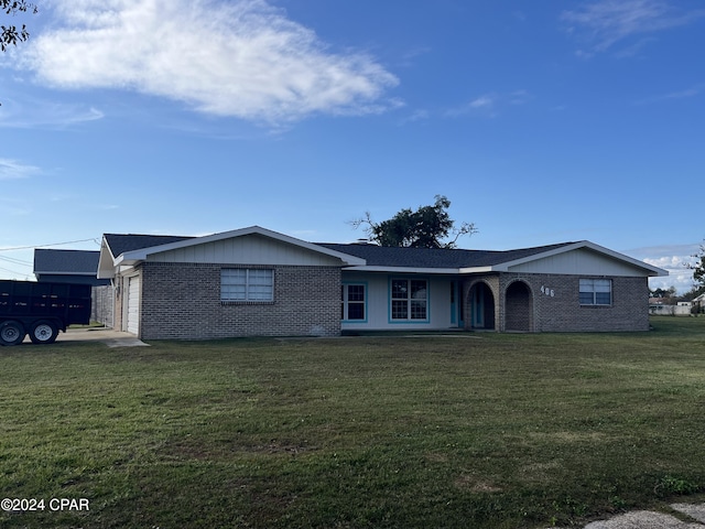 ranch-style home featuring a garage and a front lawn