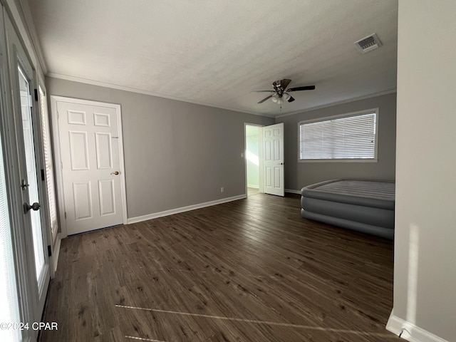 unfurnished bedroom with ceiling fan, ornamental molding, dark wood-type flooring, and multiple windows