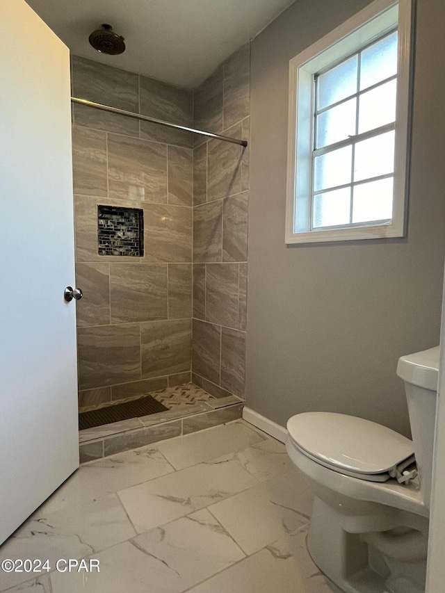 bathroom with toilet and tiled shower