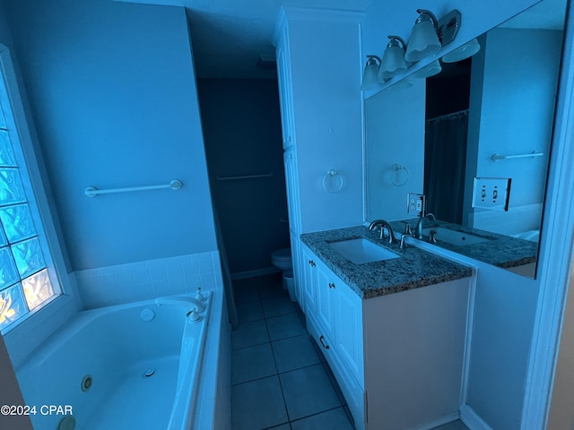 bathroom featuring tile patterned floors, vanity, toilet, and a tub to relax in