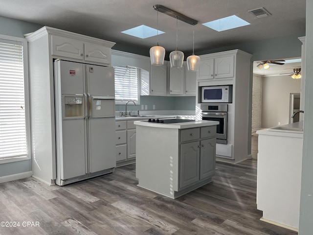 kitchen with white cabinetry, pendant lighting, and white appliances