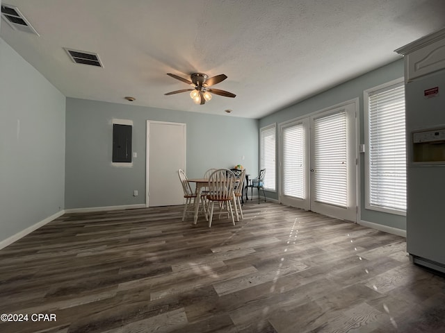 unfurnished dining area with electric panel, a wealth of natural light, ceiling fan, and dark hardwood / wood-style floors