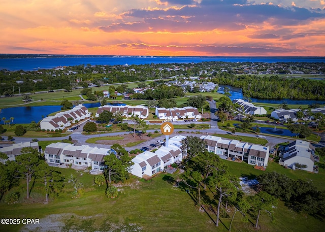 aerial view at dusk featuring a water view