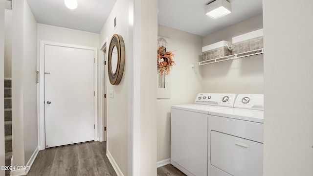 laundry area with wood-type flooring and washer and clothes dryer