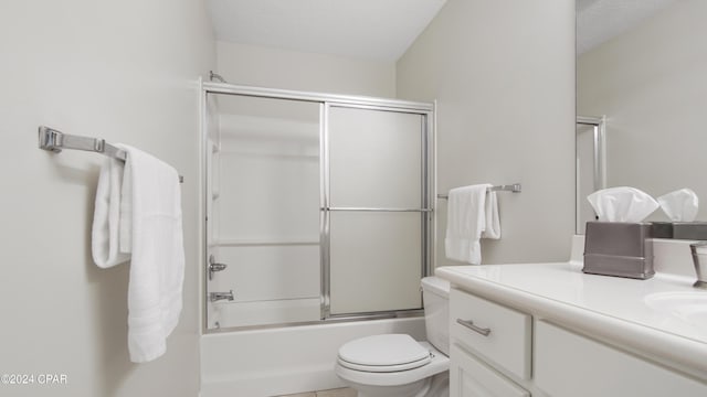 full bathroom with shower / bath combination with glass door, a textured ceiling, vanity, and toilet