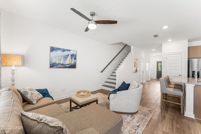 living room featuring ceiling fan and dark hardwood / wood-style flooring