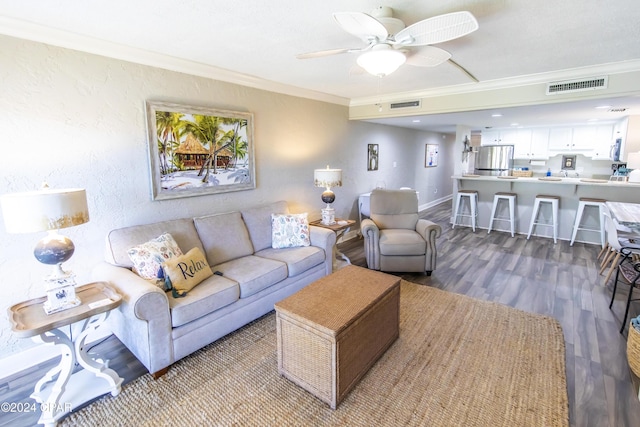 living room with ceiling fan, hardwood / wood-style floors, and ornamental molding