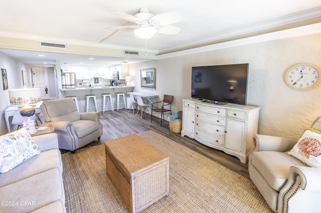 living room with ceiling fan, wood-type flooring, and ornamental molding