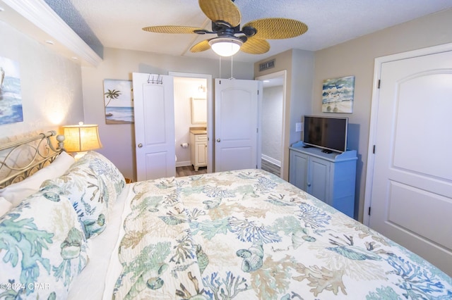 bedroom featuring ensuite bath, ceiling fan, and a textured ceiling