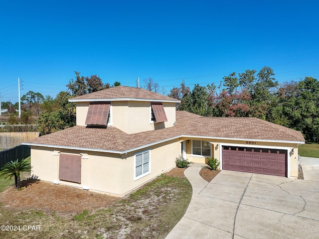 view of front of home featuring fence, roof with shingles, stucco siding, concrete driveway, and a garage