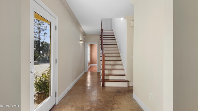 stairs with ornamental molding, baseboards, and finished concrete floors
