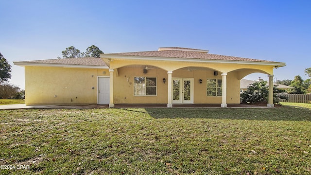 back of house with a ceiling fan, fence, a yard, stucco siding, and french doors