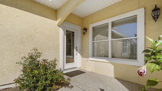 entrance to property featuring stucco siding