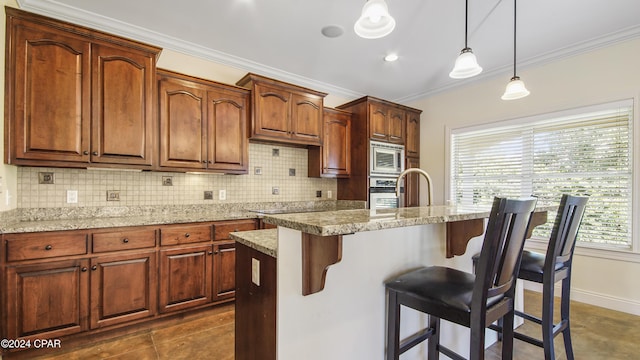 kitchen with ornamental molding, decorative backsplash, appliances with stainless steel finishes, pendant lighting, and a kitchen bar