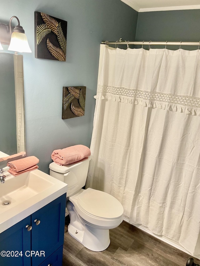 bathroom featuring crown molding, vanity, wood-type flooring, and toilet