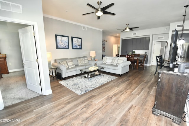 living room featuring ceiling fan, wood-type flooring, and ornamental molding