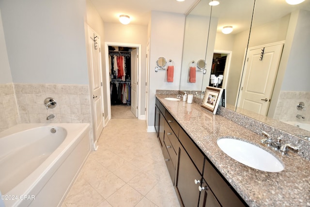 bathroom featuring a bathing tub, tile patterned flooring, and vanity