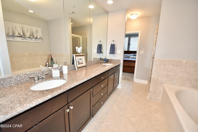 bathroom featuring tile patterned floors, vanity, and plus walk in shower