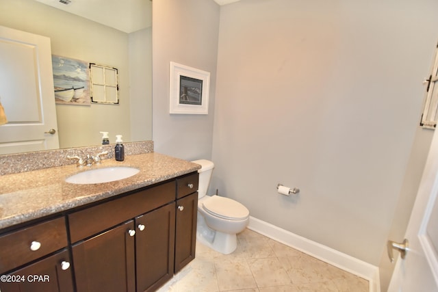 bathroom featuring tile patterned flooring, vanity, and toilet