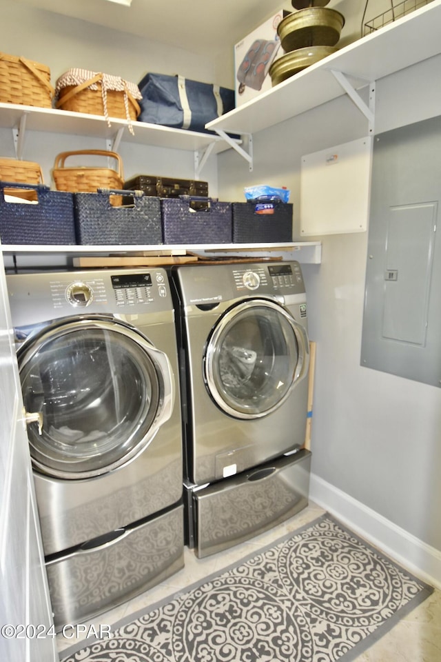 laundry area featuring tile patterned flooring, electric panel, and washer and clothes dryer