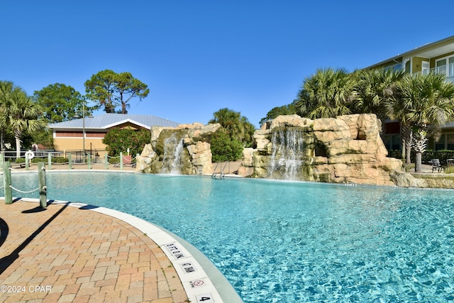 view of swimming pool with pool water feature