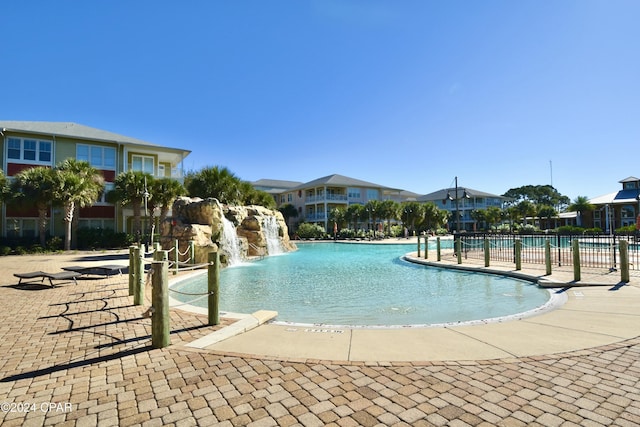 view of swimming pool with pool water feature and a patio